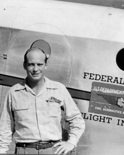 Black and White photo of a man by a plane